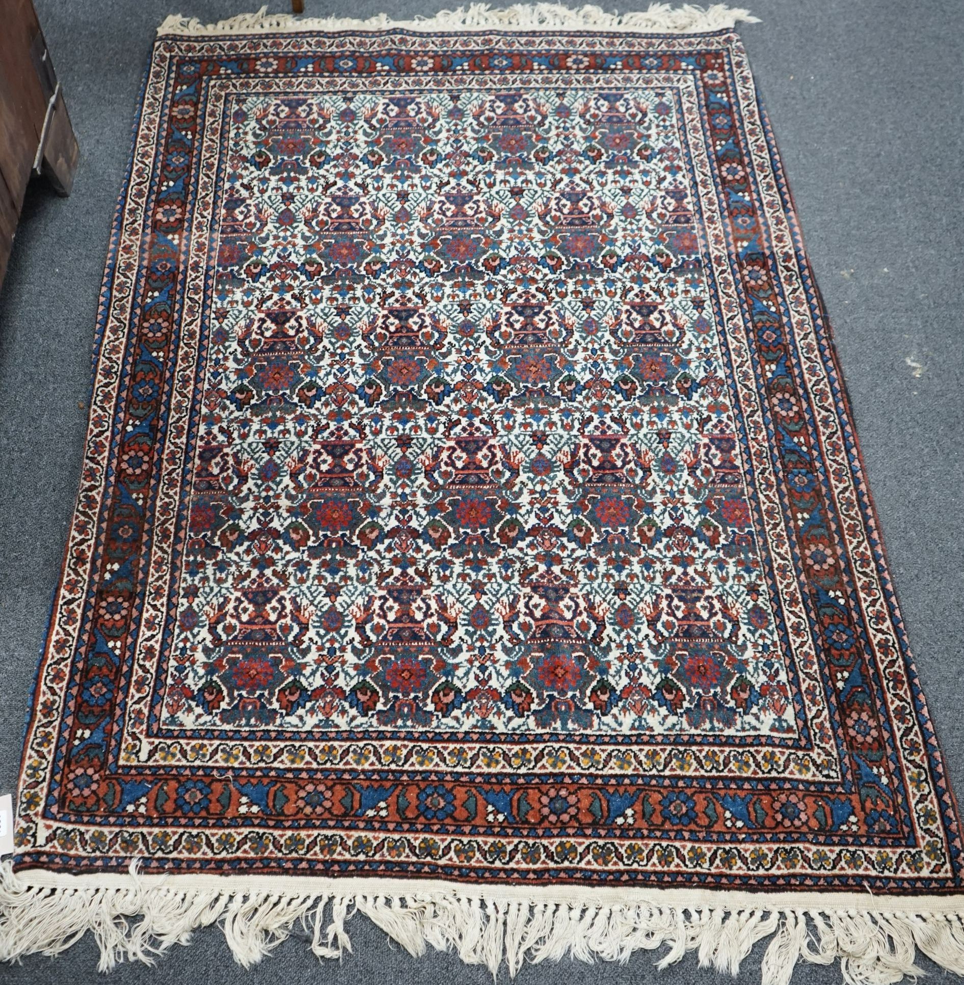 A Persian blue ground rug decorated with Zil-i-Soltan motifs on ivory fields, 106 x 152cm